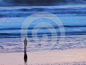 Silhouette of young woman on beach with abstract background of waves on beach