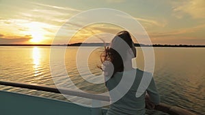 Silhouette of young woman on cruise ship at sunset