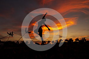 Silhouette of a young woman dancing in the sunset