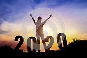 Silhouette of young woman jumping on the hill with 2020 happy new years