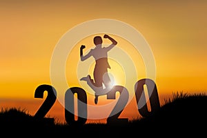 Silhouette of young woman jumping on the hill with 2020 happy new years