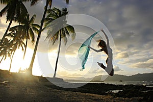 Silhouette of young woman jumping at Las Galeras beach