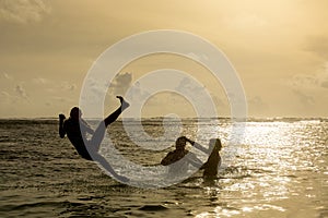 Silhouette of young woman jumping out of ocean