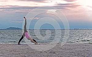 Silhouette young woman lifestyle exercising vital meditate and practicing yoga ball on the beach at sunset.