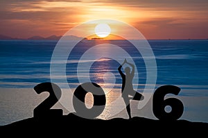 Silhouette young woman play Yoga on the sea and 2016 years while celebrating new year