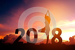 Silhouette young woman practicing yoga on 2018 new year