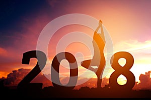Silhouette young woman practicing yoga on 2018 new year