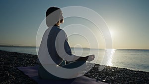 Silhouette of young woman practicing yoga on the nature at sunset. active meditation a relax concept. woman meditation