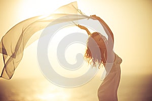 Silhouette of young woman relaxing at the beach