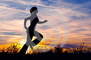 Silhouette of young woman running in nature