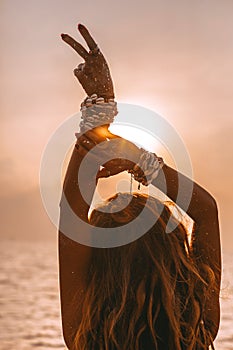 Silhouette of young woman showing victory with her fingers photo