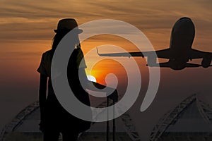 Silhouette of young woman is standing near window at the airport