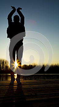 Silhouette of young woman at sunset