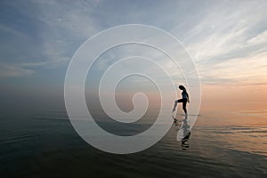 Silhouette of young woman wading in sea photo