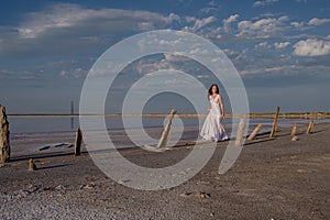 Silhouette of young woman walking on Dead Sea at sunrise. Solitude