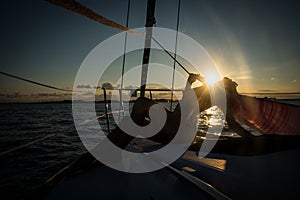 Silhouette of young women sitting on the edge of the sailboat