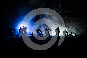 Silhouette of zombies walking over cemetery in night. Horror Halloween concept of group of zombies at night