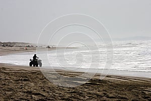 Silhouetted ATV rider on the Beach