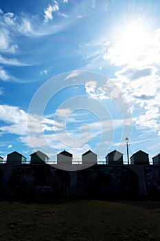 Silhouetted beach huts and a dramatic sky