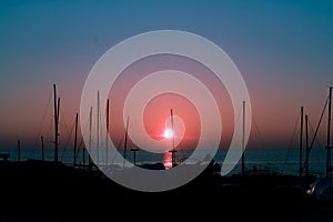 Silhouetted boats in a harbor at sunset