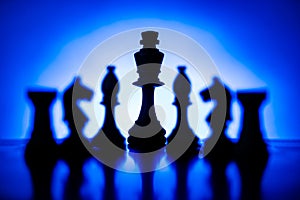 Silhouetted chess pieces against a blue gradient background