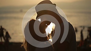 Silhouetted couple hold each other and kiss on the beach. date on the seafront