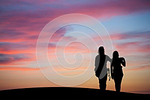 Silhouetted couple watching sunset sky