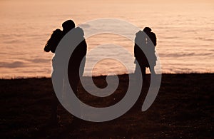 Silhouetted couples kissing above inversion fog