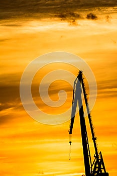 Silhouetted cranes at shipyard,