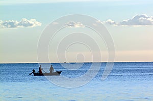 Silhouetted fishermen at sea