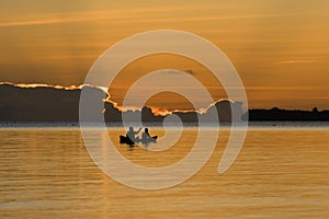 Silhouetted fishermen sitting on a boat
