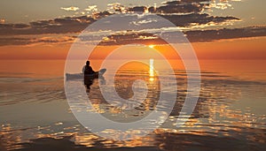 Silhouetted kayaker paddling at sunset on the sea recreational water sports adventure