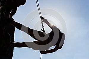 Silhouetted Man Climbing Rock