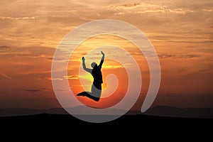 Silhouetted man jumping in sunset