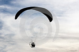 Silhouetted man with paraglider