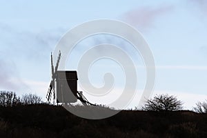 Silhouetted old wooden windmill