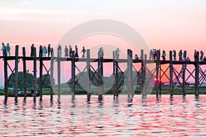 Silhouetted people on U Bein Bridge at sunset, Amarapura, Mandalay region, Myanmar