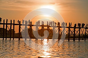 Silhouetted people on U Bein Bridge at sunset, Amarapura, Mandalay Myanmar