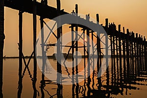 Silhouetted people on U Bein Bridge at sunset, Amarapura, Mandalay region, Myanmar