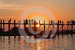 Silhouetted people on U Bein Bridge at sunset in Myanmar