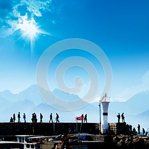 Silhouetted people walking in Antalya harbor