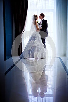 Silhouetted portrait of a bride and groom in the hotel hall