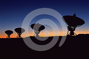 Silhouetted radio telescope dishes