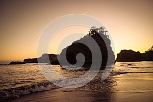 Silhouetted sea stacks in orange evening sky at Oregon Coast