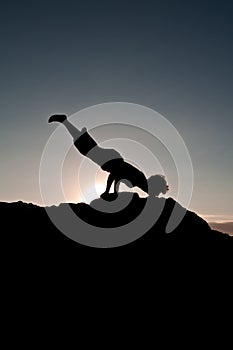 Silhouetted teen exercising