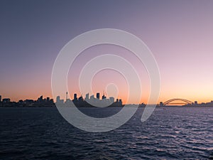 Silhouetted view of Sydney Harbour skyline at sunset, Australia