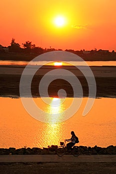 Silhouetted woman riding at Mekong river