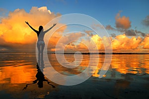 Silhouetted woman standing in a water at sunset on Taveuni Island, Fij