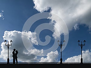 Silhouetted young lovers on a promenade