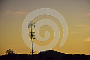 Silhouettes of antennas at orange sunset